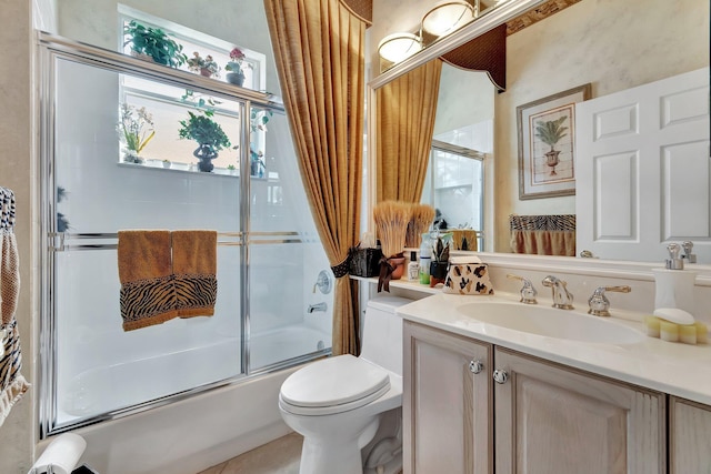 full bath with vanity, toilet, and combined bath / shower with glass door