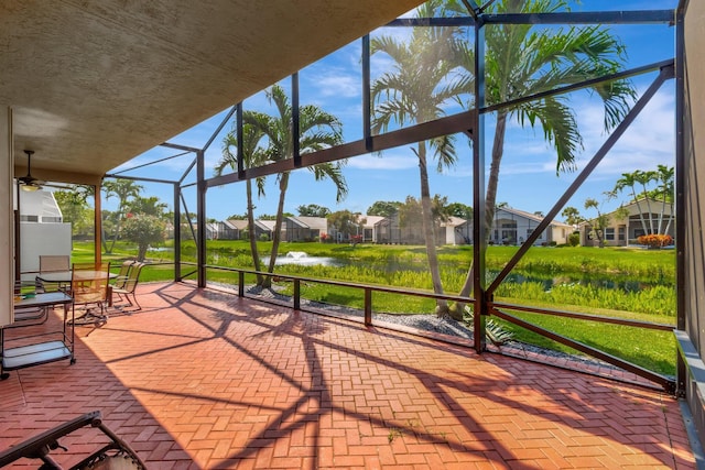 view of patio / terrace featuring ceiling fan, a residential view, and a lanai