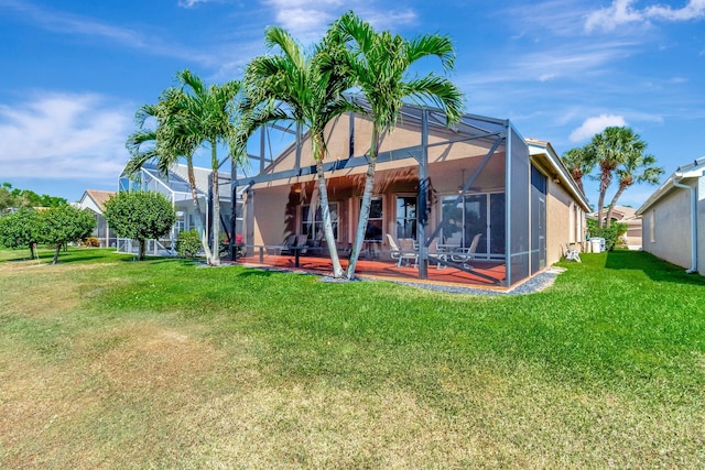 back of property featuring a lanai, stucco siding, a patio, and a yard