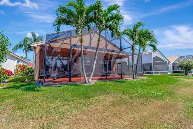 back of house featuring glass enclosure, a patio area, a lawn, and stucco siding