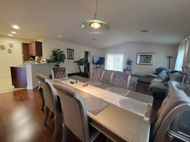 dining room with wood finished floors, visible vents, baseboards, lofted ceiling, and recessed lighting