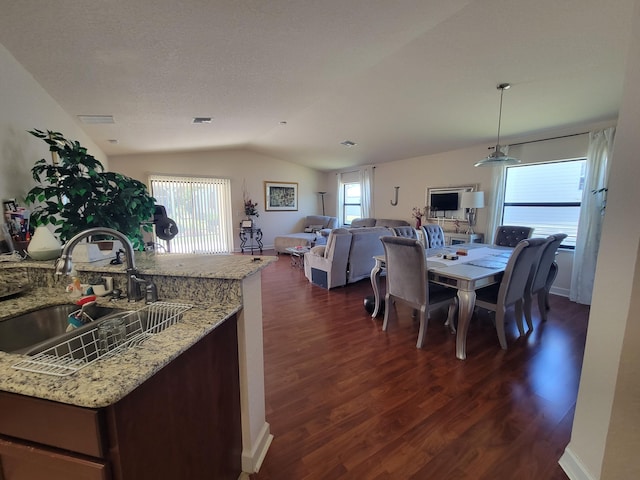 dining space with vaulted ceiling, dark wood-style floors, visible vents, and a healthy amount of sunlight
