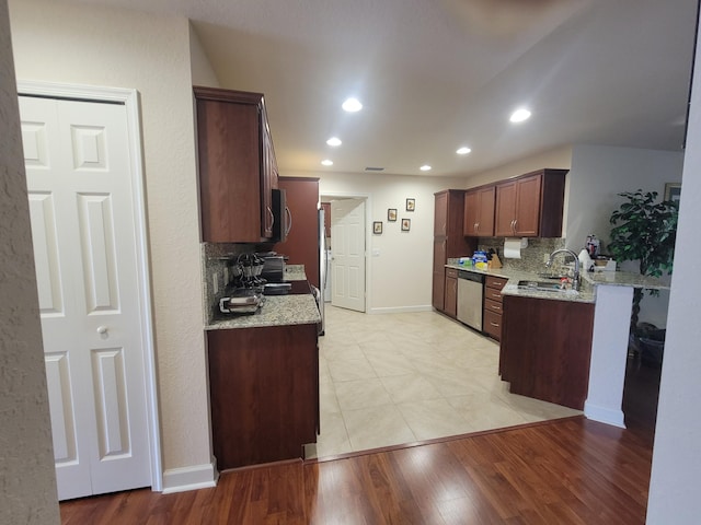 kitchen with recessed lighting, a sink, light wood-style floors, appliances with stainless steel finishes, and backsplash