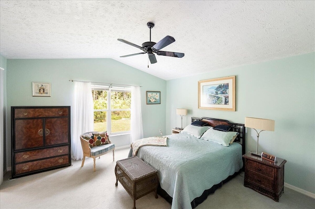 bedroom with lofted ceiling, a ceiling fan, carpet floors, and a textured ceiling