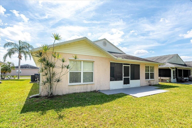 rear view of property with a yard, a patio area, cooling unit, and a sunroom