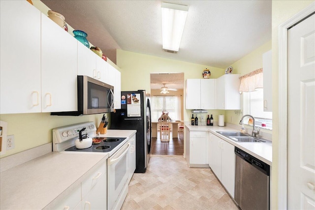 kitchen with a sink, white cabinetry, appliances with stainless steel finishes, light countertops, and lofted ceiling