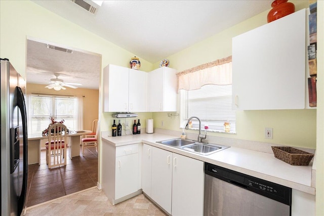 kitchen with white cabinets, appliances with stainless steel finishes, light countertops, and a sink