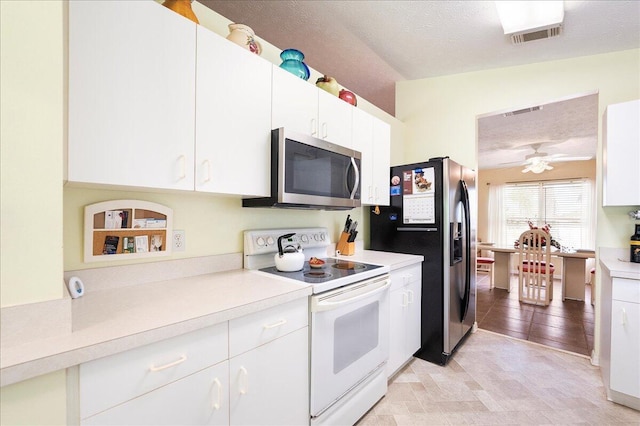 kitchen featuring light countertops, white cabinets, appliances with stainless steel finishes, and a textured ceiling