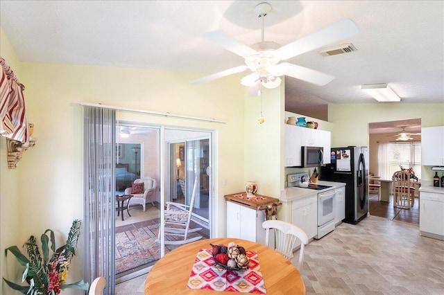 dining room with visible vents, ceiling fan, and vaulted ceiling