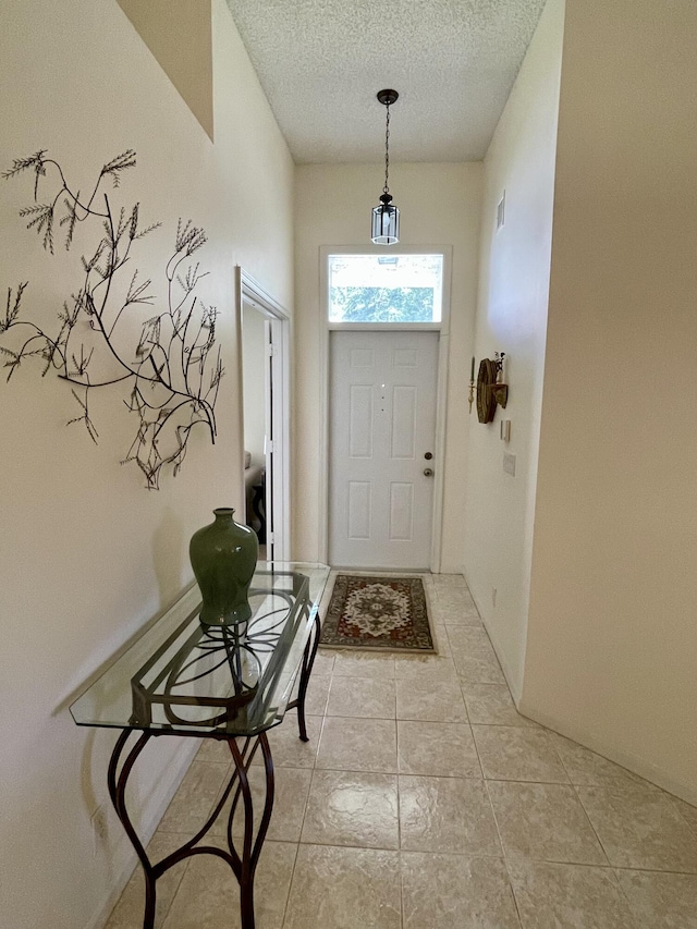 doorway with light tile patterned flooring, visible vents, and a textured ceiling