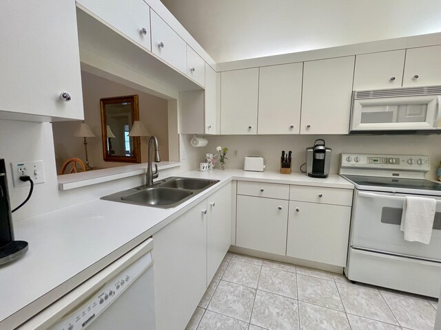 kitchen with white appliances, light tile patterned flooring, light countertops, and a sink
