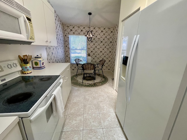 kitchen with wallpapered walls, light countertops, light tile patterned floors, white cabinets, and white appliances