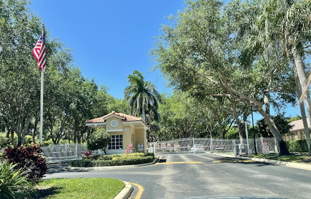 view of street featuring a gated entry, curbs, and a gate