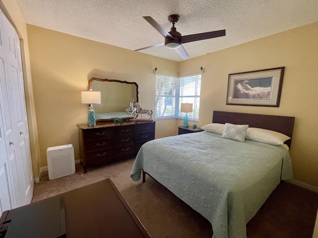 bedroom with a textured ceiling, a ceiling fan, baseboards, and light carpet