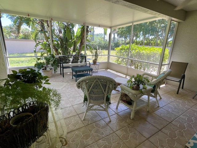 sunroom featuring an outdoor living space, a textured wall, and stone tile flooring