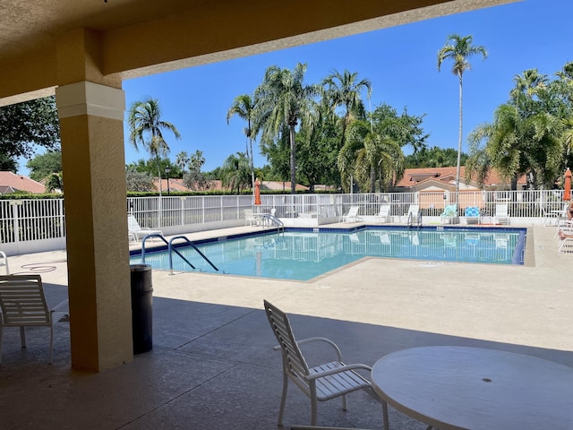 pool with a patio and fence