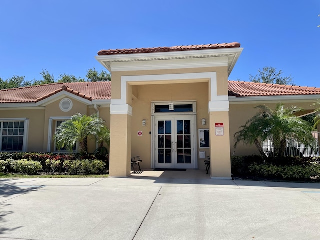 doorway to property featuring french doors, stucco siding, and a tile roof