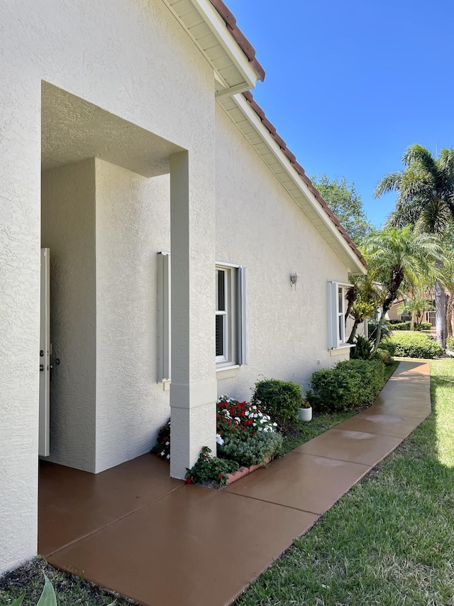 view of home's exterior with stucco siding and a tiled roof