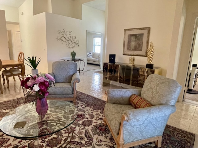 living area with tile patterned flooring and a towering ceiling
