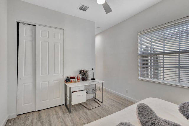 bedroom with baseboards, ceiling fan, light wood-style flooring, visible vents, and a closet