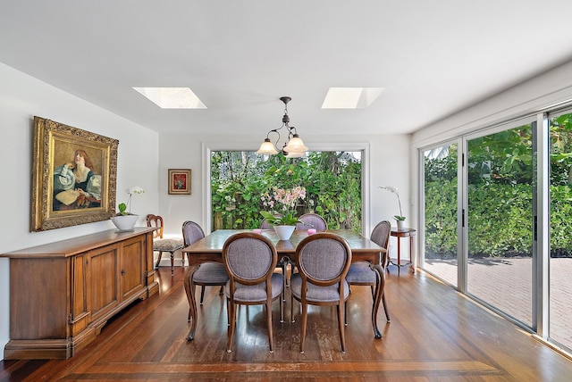 dining area featuring a chandelier, a skylight, and dark wood-style flooring