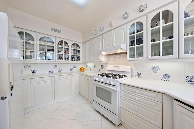 kitchen with backsplash, gas range gas stove, glass insert cabinets, and under cabinet range hood