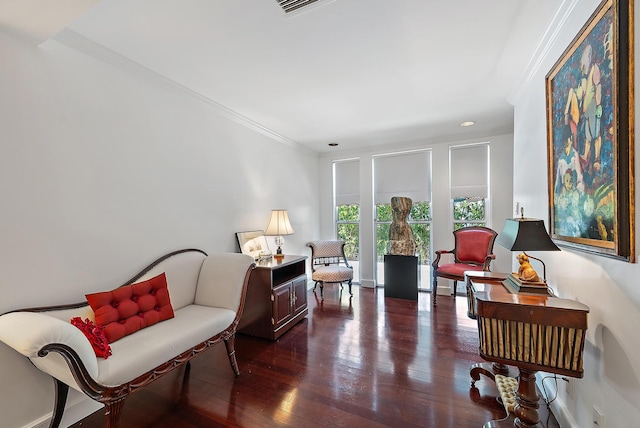 living area with dark wood-style flooring and crown molding