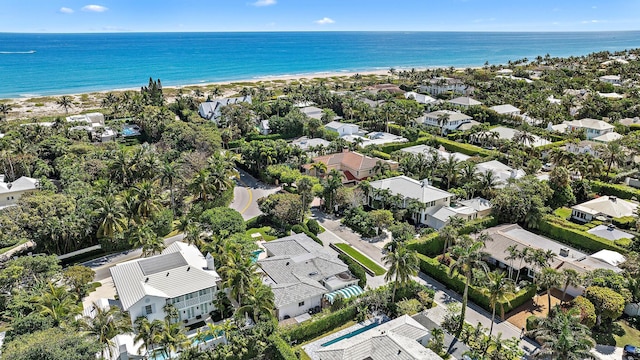 drone / aerial view featuring a residential view, a water view, and a beach view