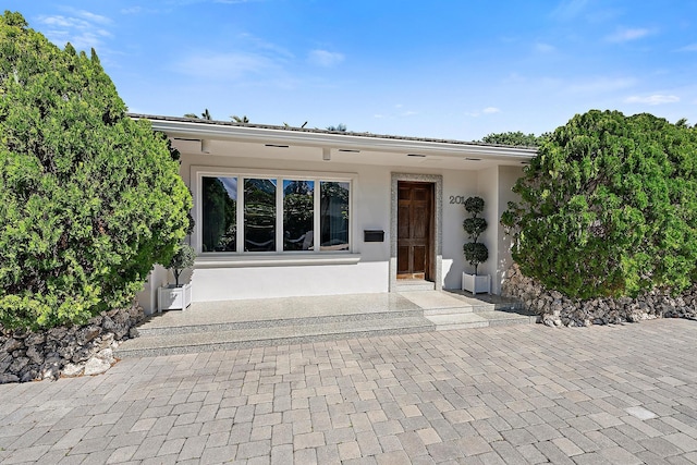 doorway to property featuring stucco siding