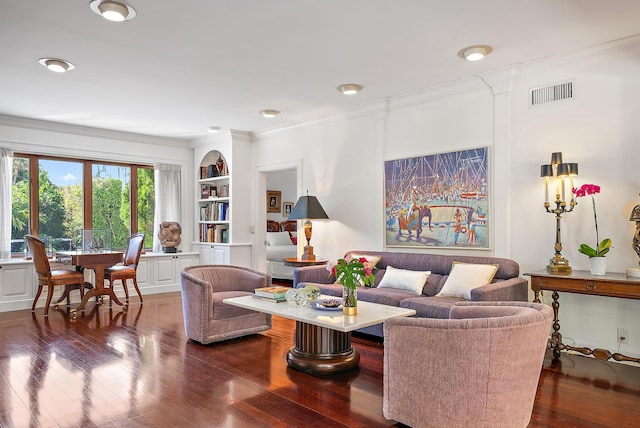 living room featuring dark wood-type flooring, built in features, visible vents, and ornamental molding