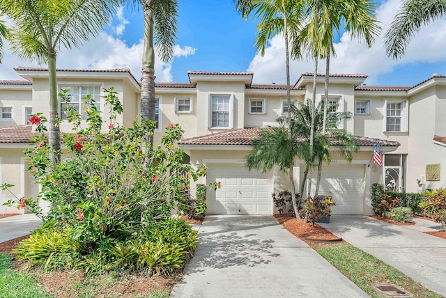 mediterranean / spanish home with a tile roof, driveway, and stucco siding