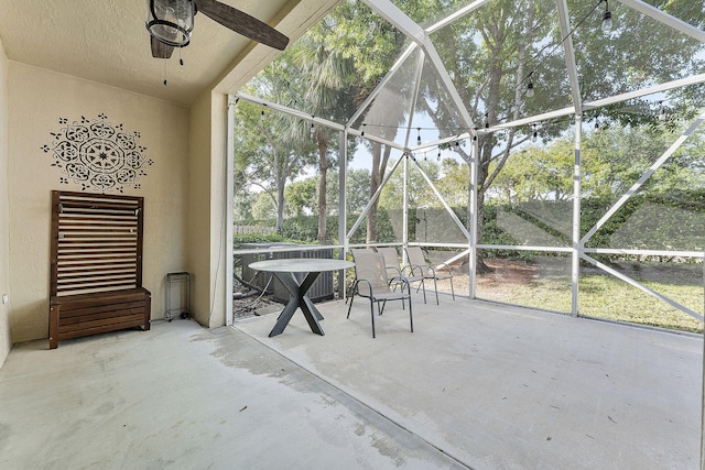 unfurnished sunroom featuring a ceiling fan