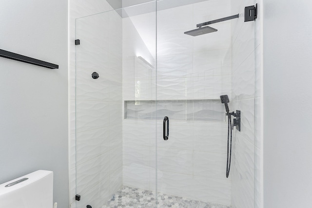 full bathroom featuring a stall shower and toilet