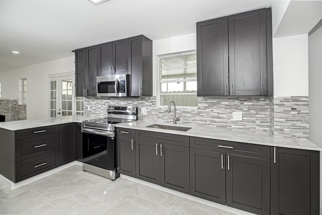 kitchen featuring a sink, stainless steel appliances, plenty of natural light, and a peninsula