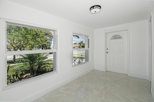 entryway with marble finish floor, crown molding, and baseboards