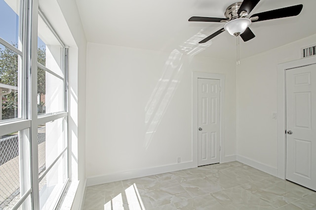 spare room with visible vents, baseboards, and ceiling fan