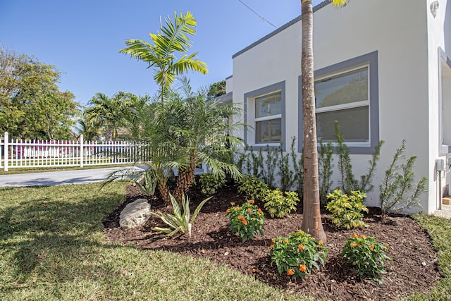 exterior space featuring a yard, fence, and stucco siding