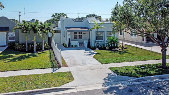 view of front facade featuring stucco siding, concrete driveway, and a front lawn