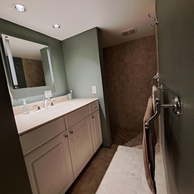 full bathroom featuring tile patterned floors, visible vents, vanity, and a walk in shower