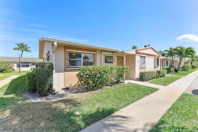 view of front of home featuring stucco siding and a front lawn