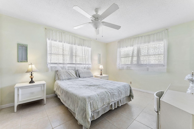 bedroom featuring multiple windows, a textured ceiling, and light tile patterned flooring