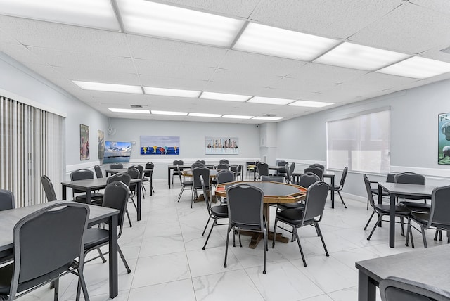 dining room featuring visible vents, marble finish floor, and a drop ceiling