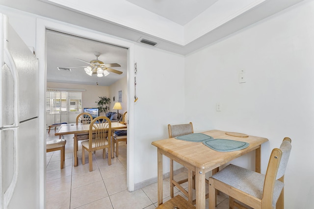 dining space featuring light tile patterned flooring, visible vents, baseboards, and ceiling fan