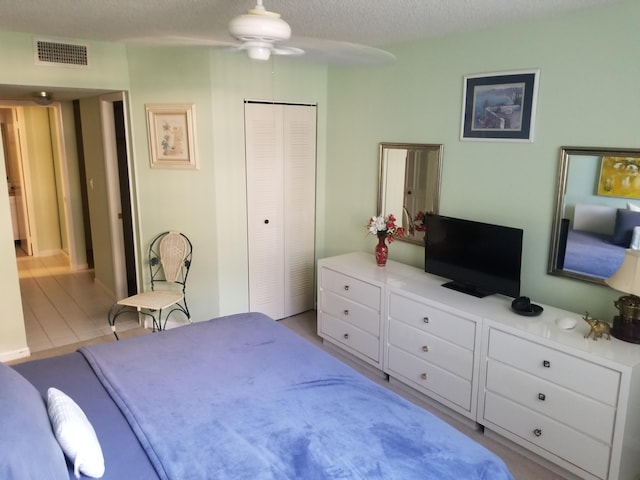 bedroom featuring a closet, visible vents, and a textured ceiling