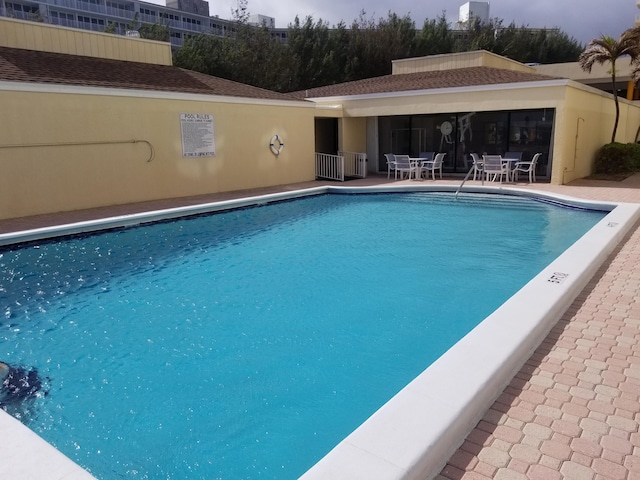 community pool featuring outdoor dining space and a patio area