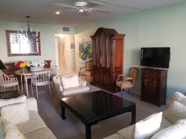 living area featuring visible vents, light colored carpet, a textured ceiling, and ceiling fan