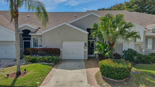 9238 E Vineland Ct E Unit E, Boca Raton, FL 33496 - view of front of home featuring stucco siding, an attached garage, concrete driveway, and roof with shingles