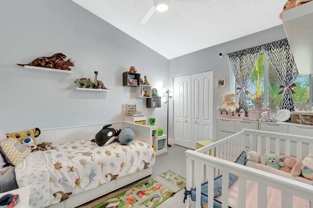 9238 E Vineland Ct E Unit E, Boca Raton, FL 33496 - bedroom with a wainscoted wall, a ceiling fan, a textured ceiling, a closet, and lofted ceiling