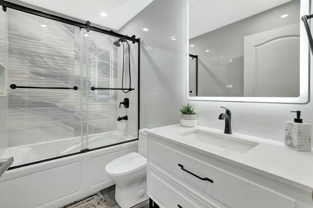 9238 E Vineland Ct E Unit E, Boca Raton, FL 33496 - bathroom featuring vanity, toilet, and bath / shower combo with glass door