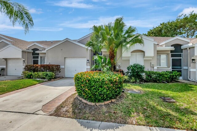 9238 E Vineland Ct E Unit E, Boca Raton, FL 33496 - view of front of house featuring stucco siding, driveway, a front yard, and an attached garage